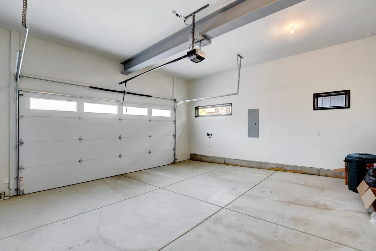 An organized and clean interior garage space, showcasing the garage door, ample flooring, and walls suitable for gear storage. The environment is practical and well-maintained, suitable for outdoor enthusiasts needing to store bikes, skis, or other equipment.