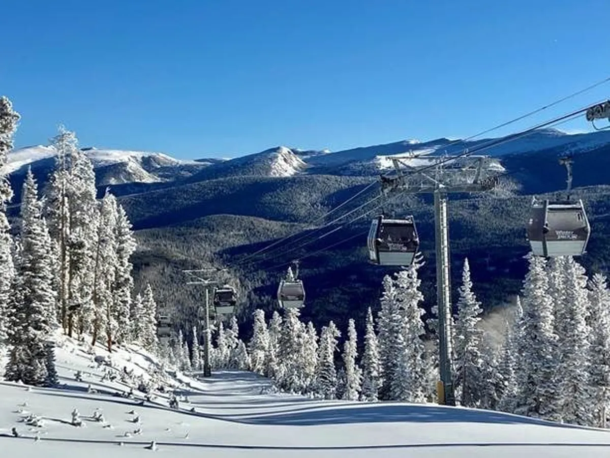 A panoramic shot of snow-covered slopes, tall pines, a ski lift, and distant mountain ranges, conveying the excitement of winter sports and serene alpine beauty. The scene is filled with the promise of skiing, snowboarding, and tranquil mountain exploration.